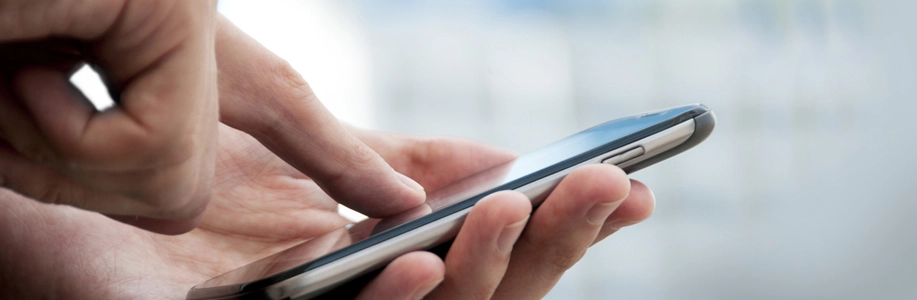 Close up of finger texting on cell phone