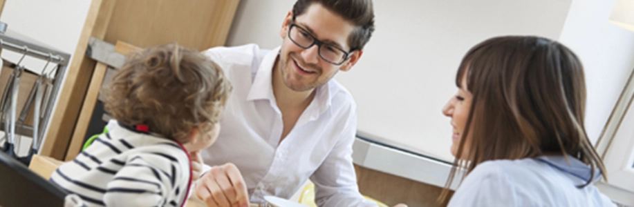Young family of three at dinner table